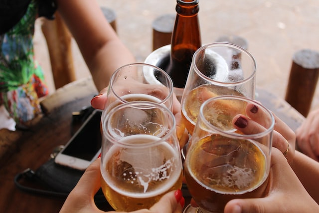 people clinking beer glasses