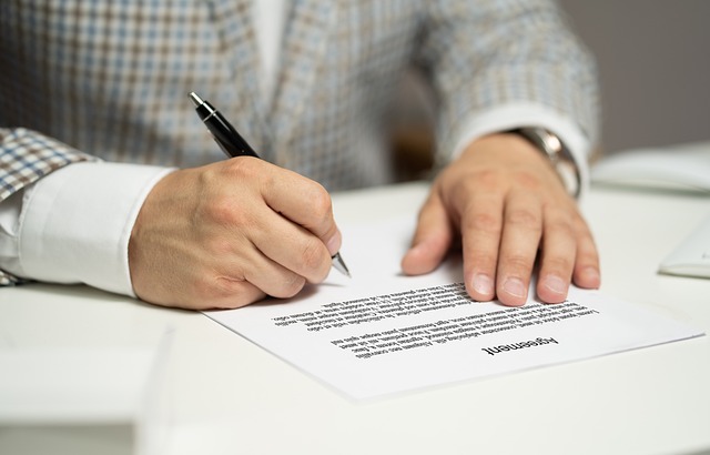 man signing document